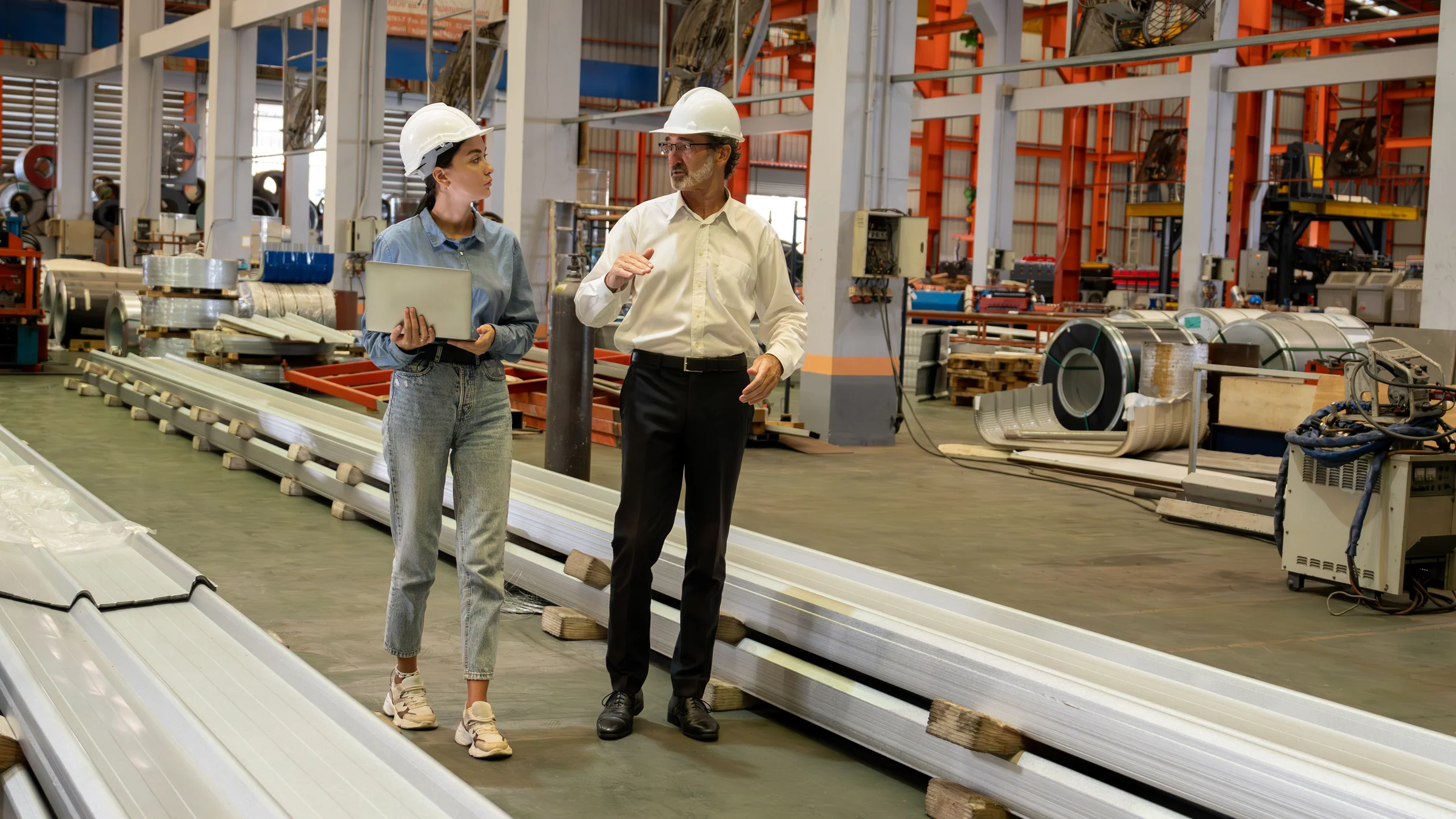 A strategic adviser and manufacturing executive walking through a facility while discussing operations.